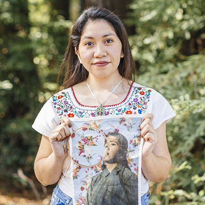 Woman holding a printed photograph embellished with embroidery