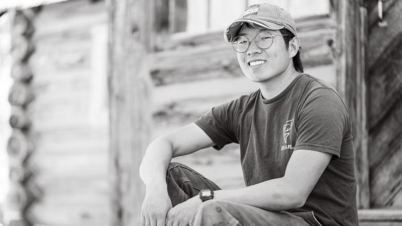 Juyung Yoo on the porch of a cabin at Valentine Ranch