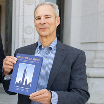 Mike Alvarez Cohen holds a copy of his book