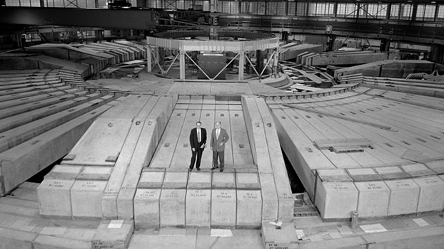 Scientists standing on room-size scientific instrument