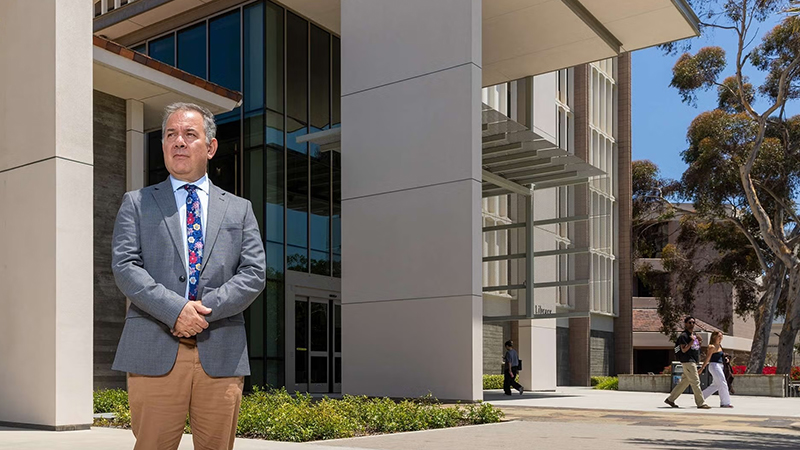 Man wearing a suit standing in front of a building