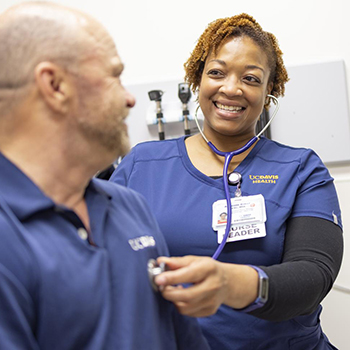 UC Davis Health nurse listening to a colleague's heartbeat