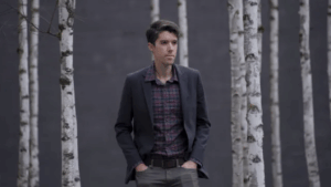 Daniel standing amongst birch trees in a forest