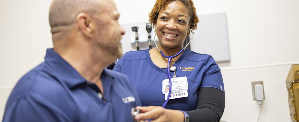 UC Davis Health nurse listening to a colleague's heartbeat