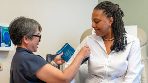 Uniformed woman checking another woman's blood pressure