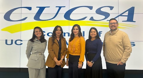 Group of people standing in front of the CUCSA logo