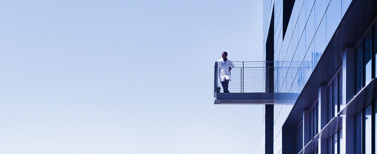 Person on the balcony of a tall building.