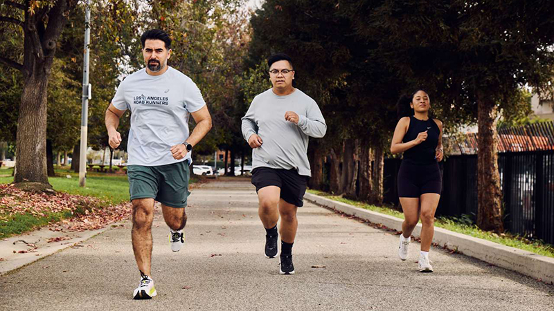 Three people running on the UCLA campus