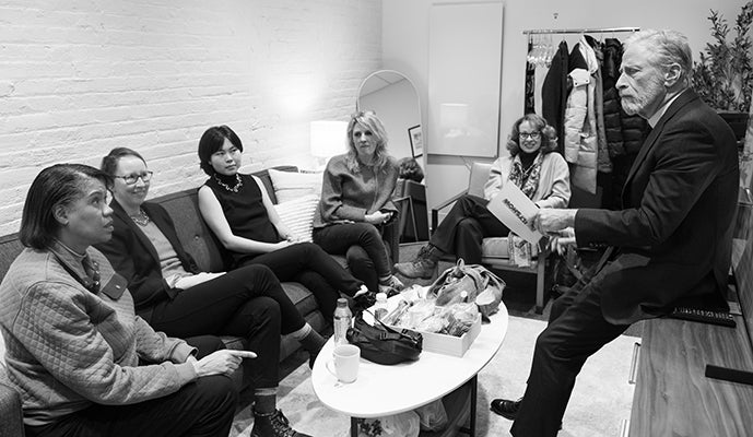 Black and white image of group of people sitting together on sofa, including Mechele and Maura