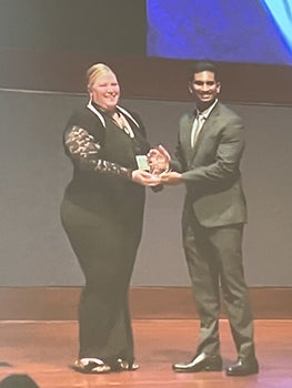 Yash accepting award from tall woman