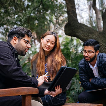 Three people working around a tablet at UCLA