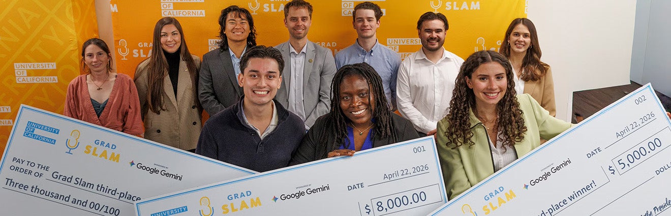 A group of smiling students, three of them holding giant prize money checks