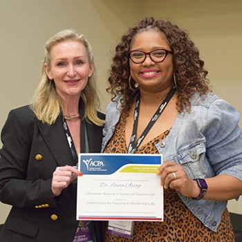 Two women holding a certificate between them