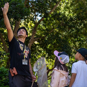 Boaz Solorio gestures for students with an outstretched hand