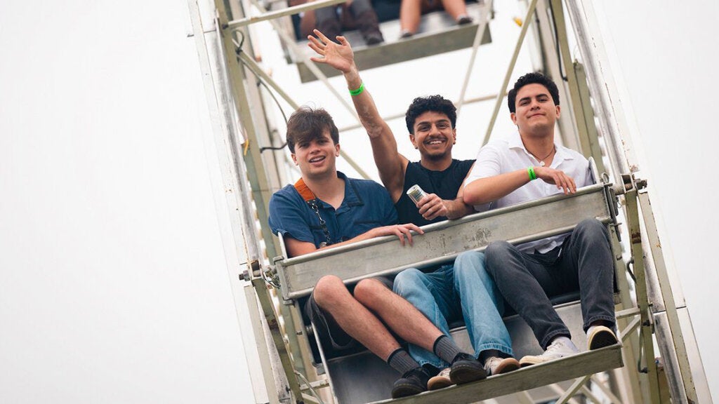 Three students sit in a ferris wheel gondola