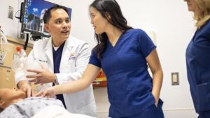 Man demonstrating nursing technique for colleagues on plastic dummy