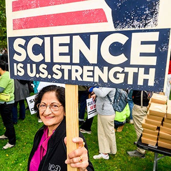 Woman holding a sign that reads "Science is U.S. strength."