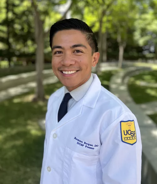 Roman Roque headshot in doctor's jacket