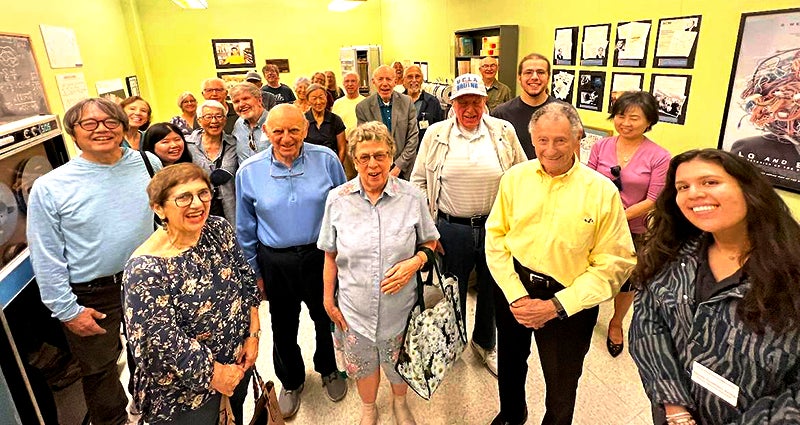 A group of retirees posing for a picture together in a UCLA building
