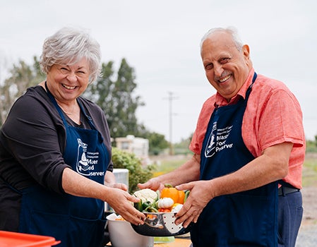Man and woman master preservers working on pickles