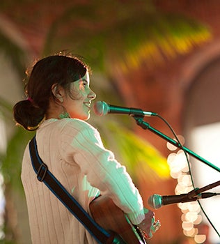 Woman playing guitar in an alcove