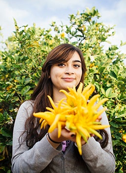 Marianela Henriquez with a Buddha's hand citron at the Citrus Station.