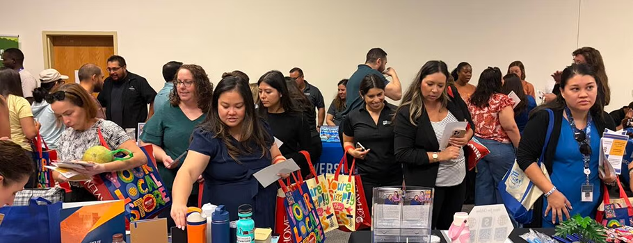 Group of people visiting vendor tables.