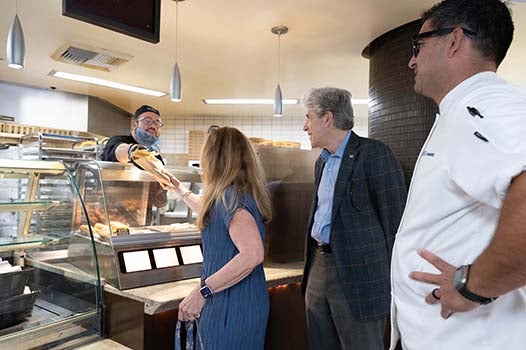 Felicia Knaul, associate of the chancellor, and Chancellor Julio Frenk at a Bruin Plate station as Joey Martin looks on.
