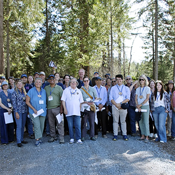 large group of people standing in the woods