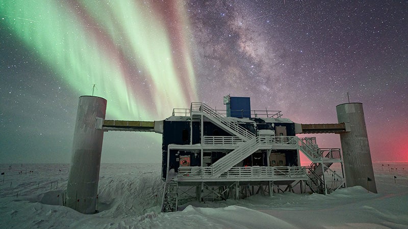 Concrete facility surrounded by stars and Northern Lights